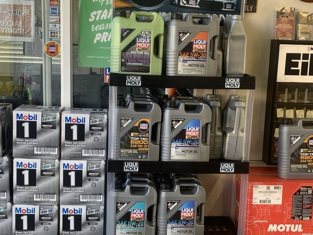 Sealed bottles of Mobil 1, MOTUL, and Liqui Moly oil on the Perfect Lube product shelf
